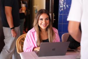 student smiling and working on laptop