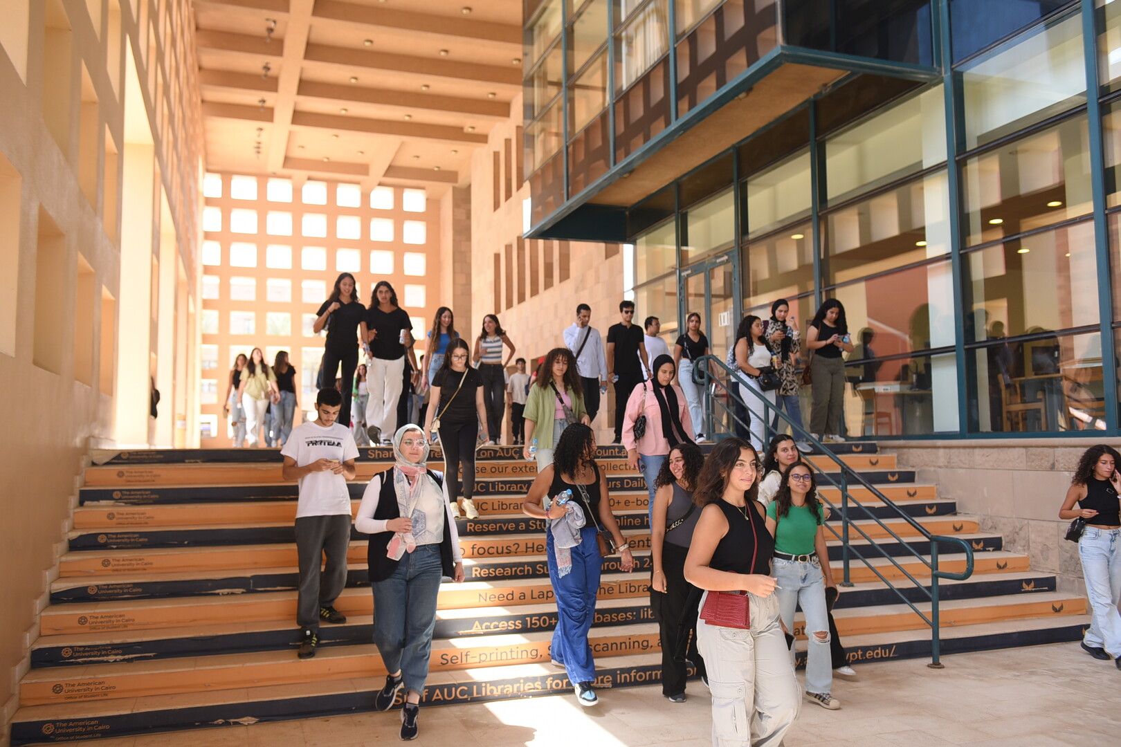 groups of students going down the stairs in front of the library