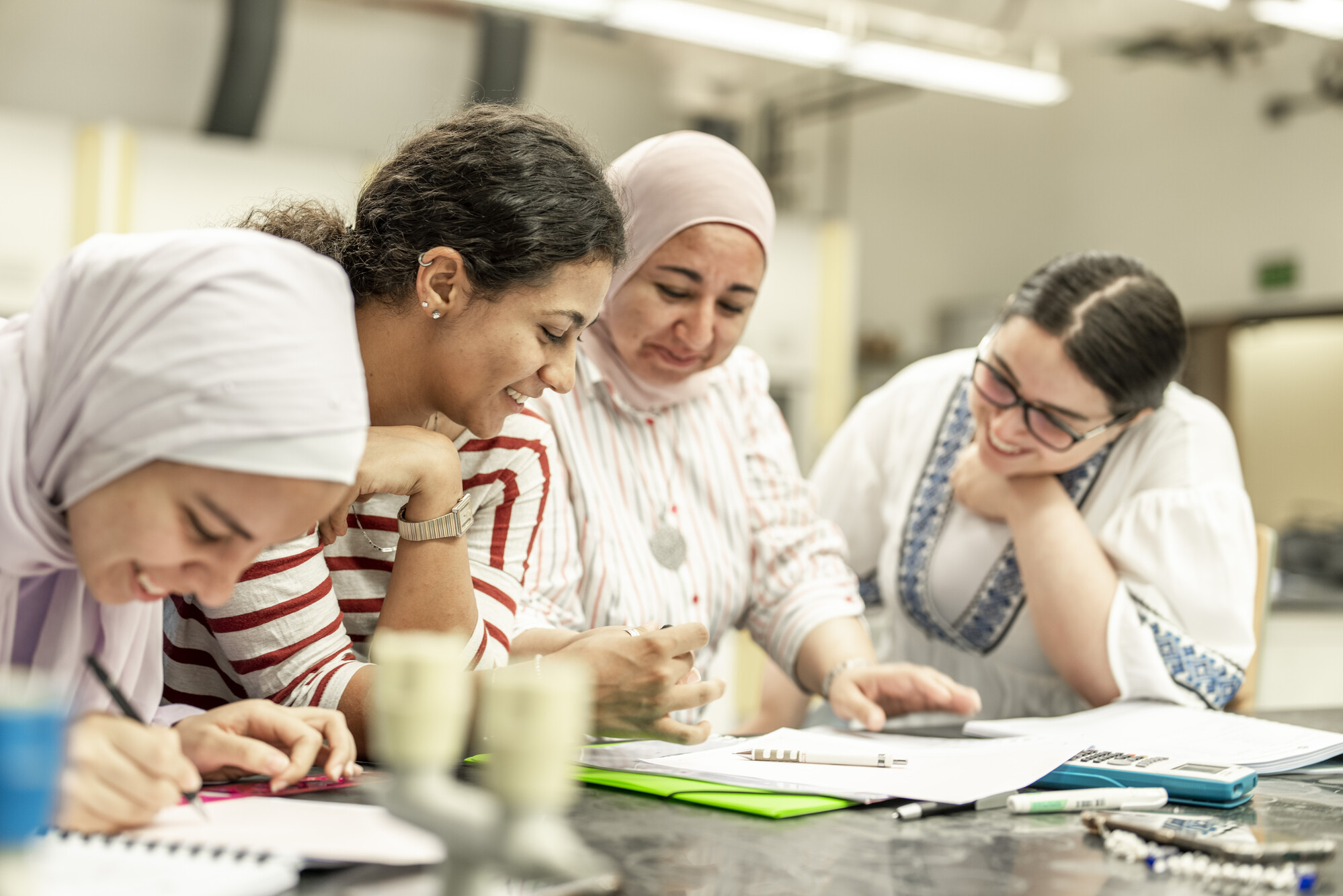 group of female students working together in classroom on a project