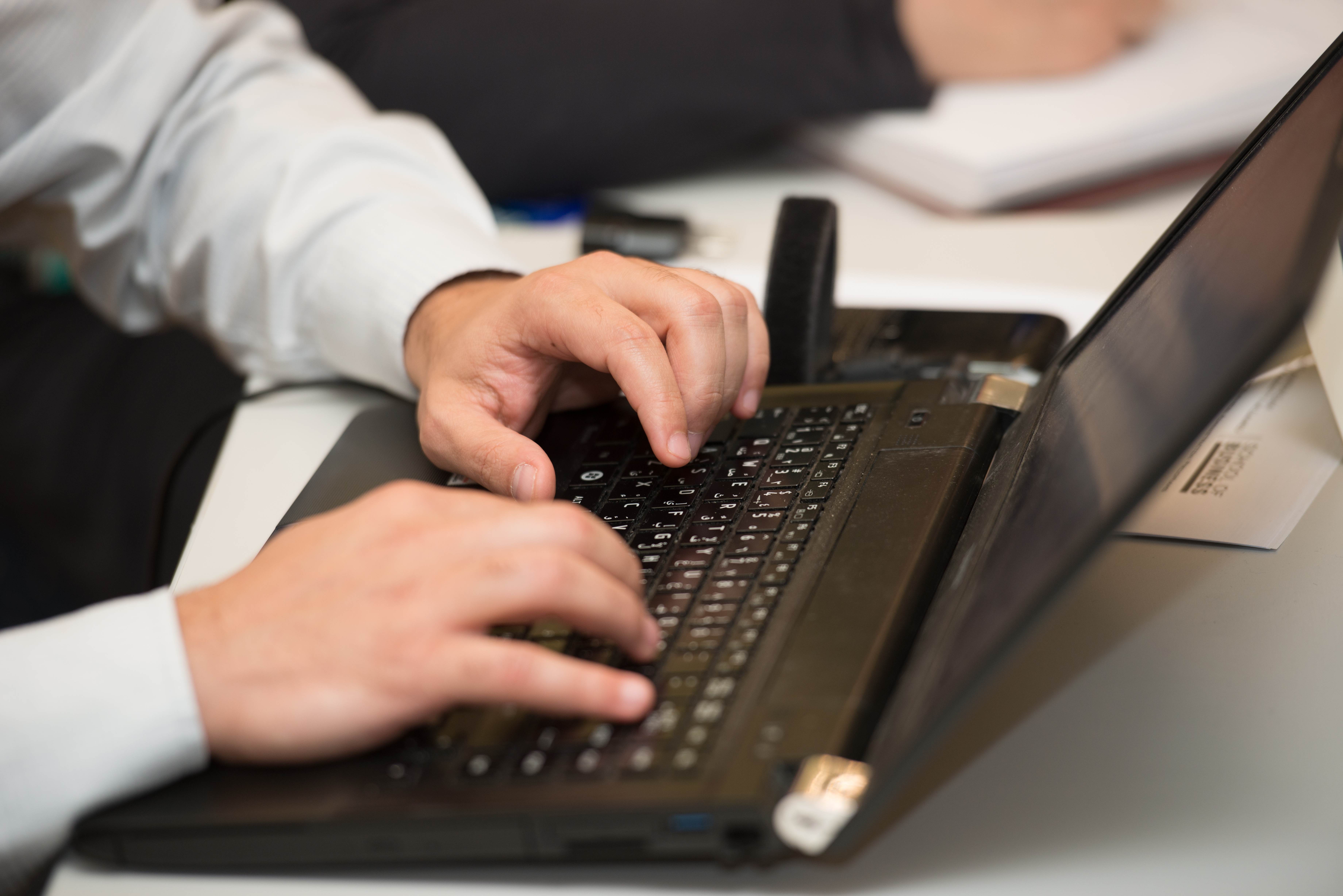 male student typing on the laptop