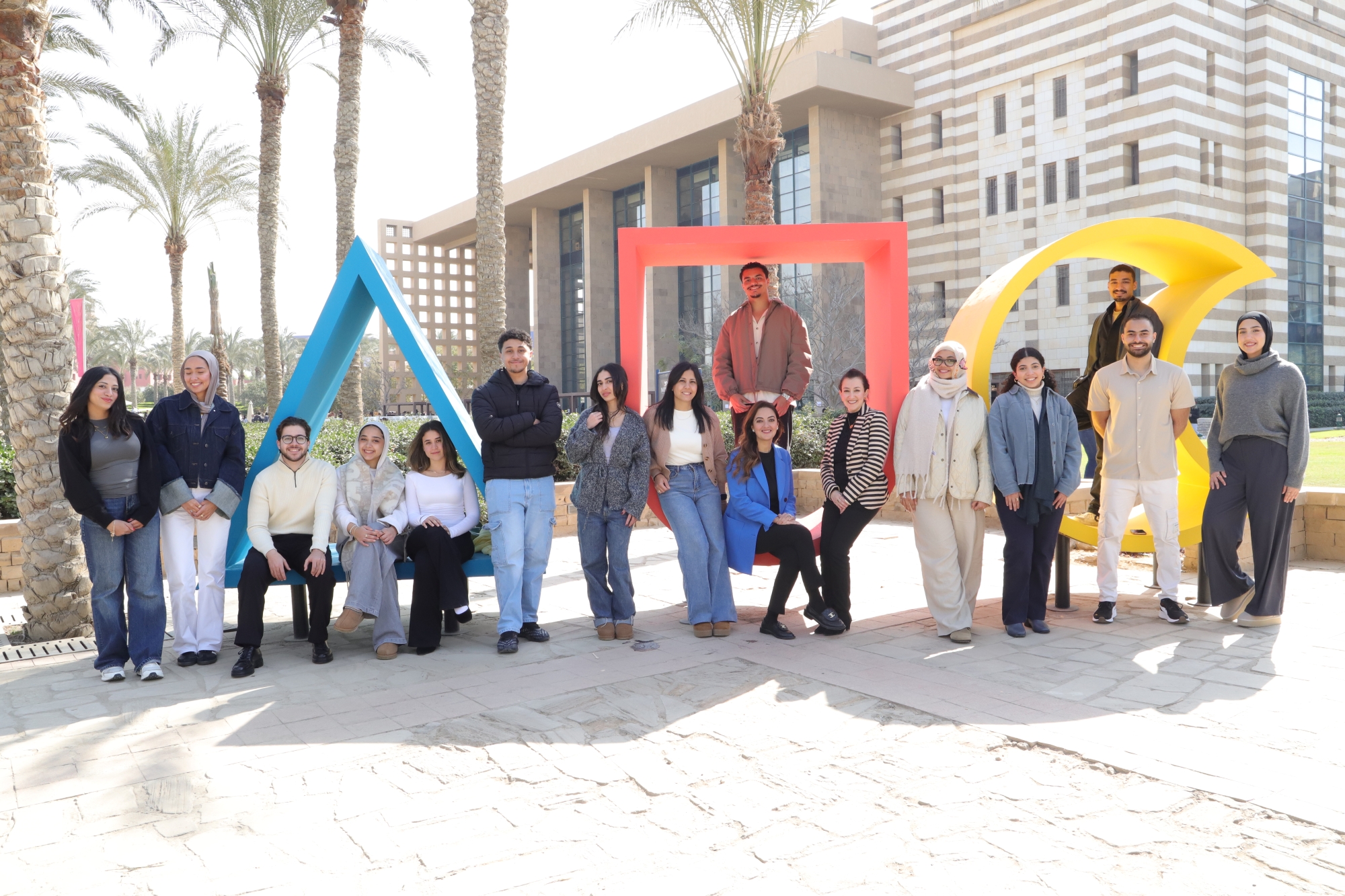 group of students infront of AUC logo in the gardens 
