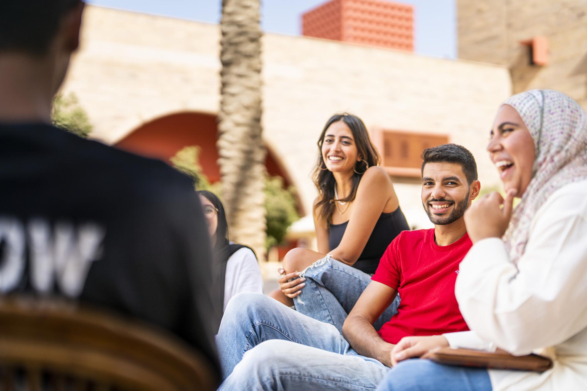 group of smiling students talking on campus