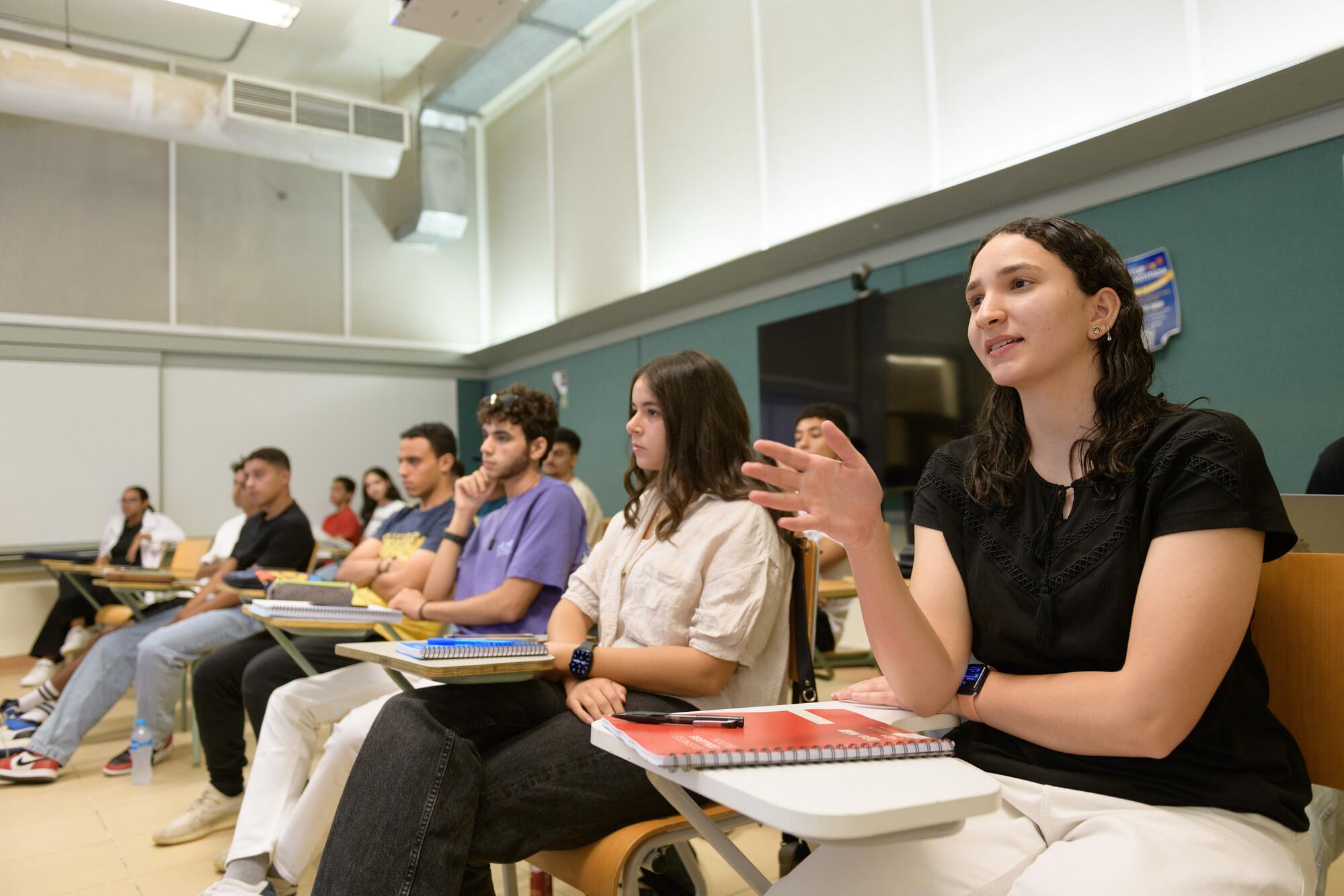 students in classroom asking questions and interacting with professor