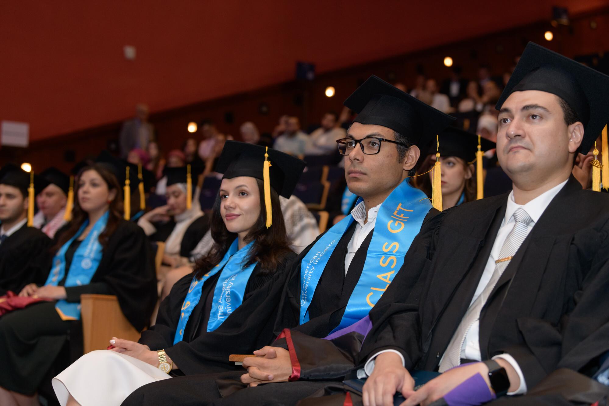 graduate students in commencement wearing cap and gown