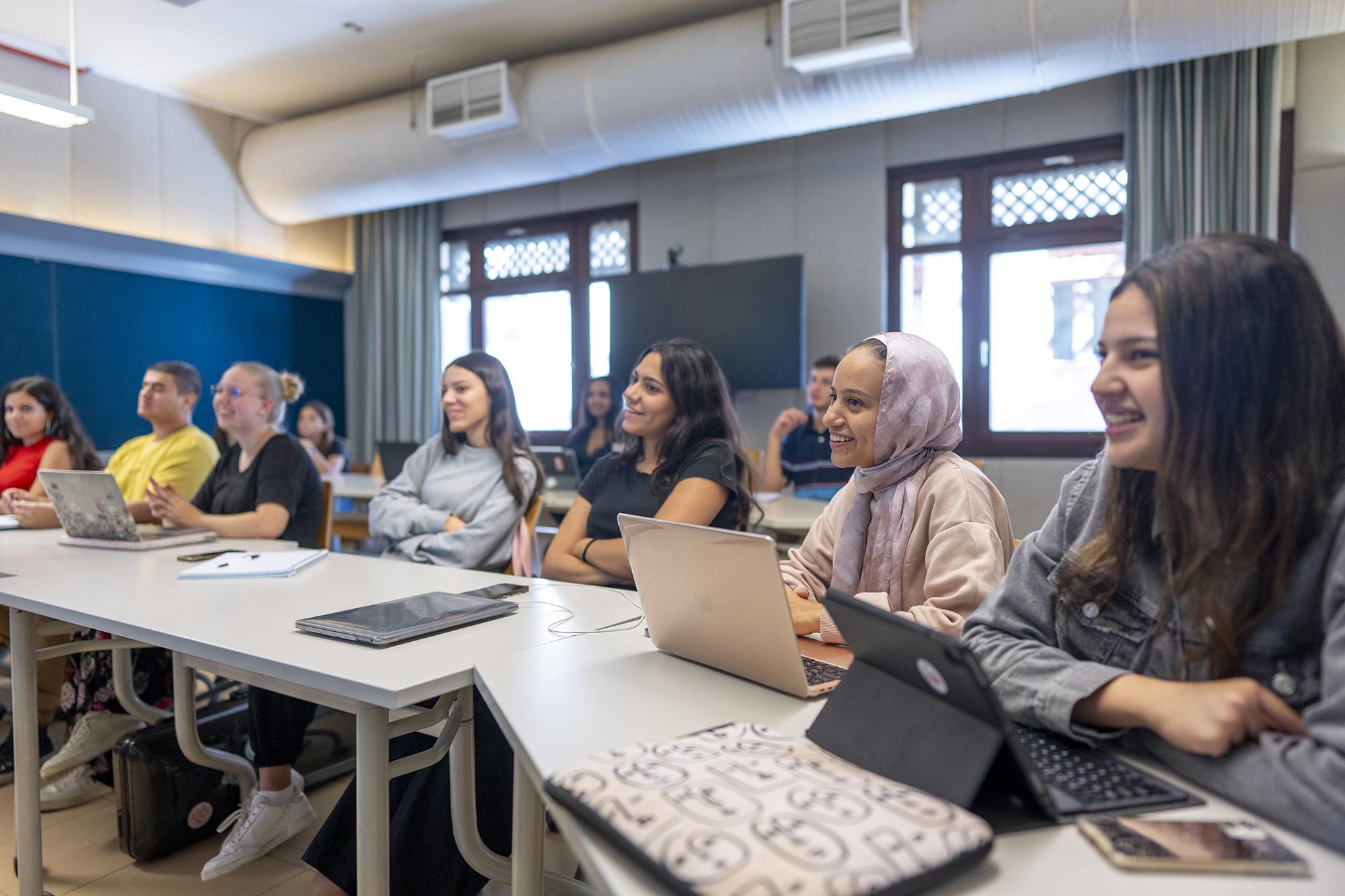 students smiling and focusing in class