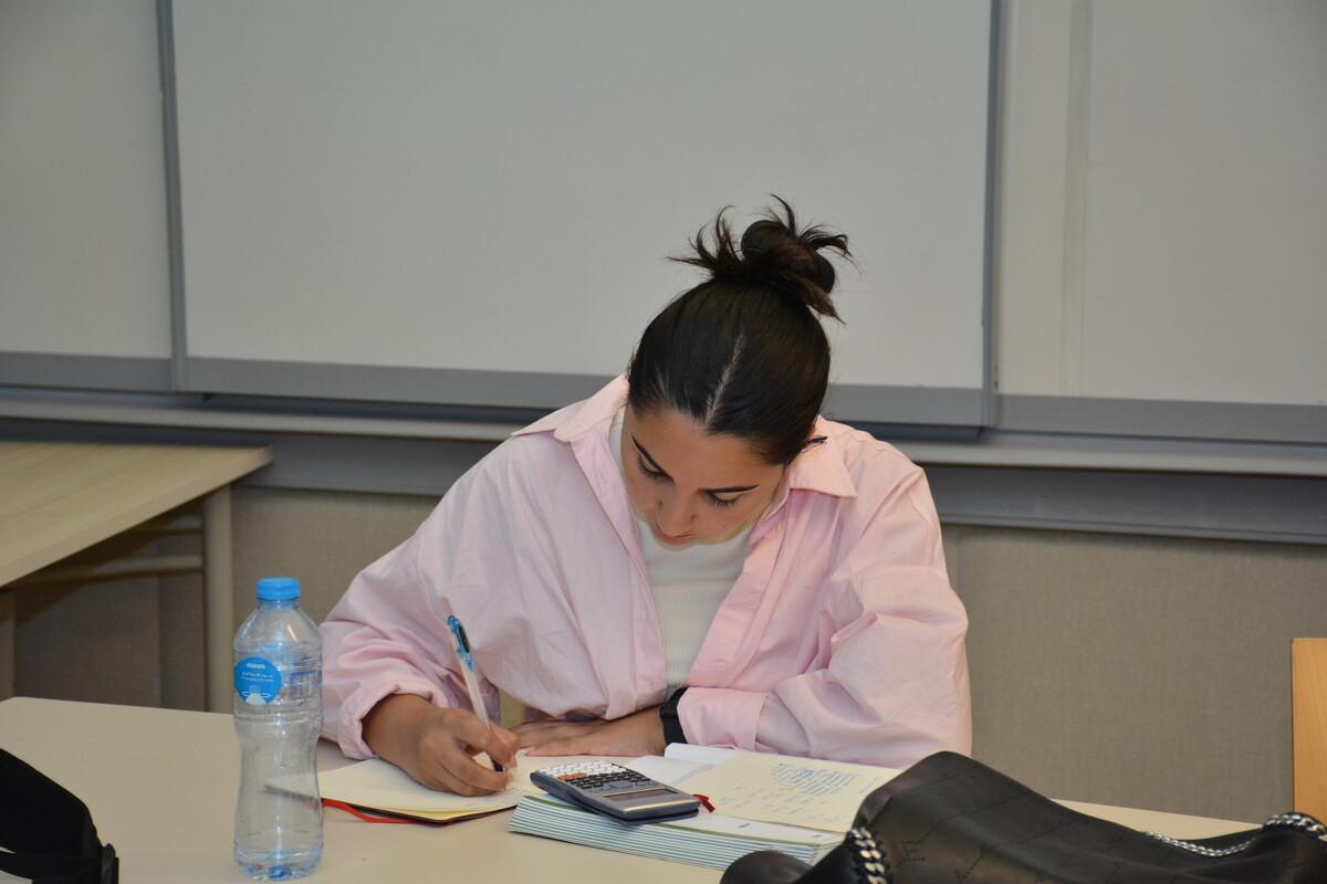 student writing assignment in class and working on paper