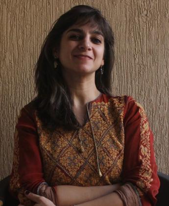 A woman is smiling and crossing her arms