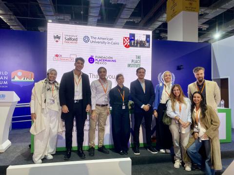 A group of men and women, including AUC architecture faculty and students, standing next to each other and smiling at the World Urban Forum