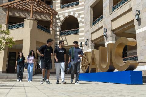 Students walking in front of a building at the New Cairo campus 