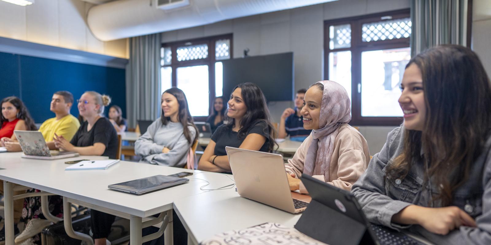 students smiling and focusing in class
