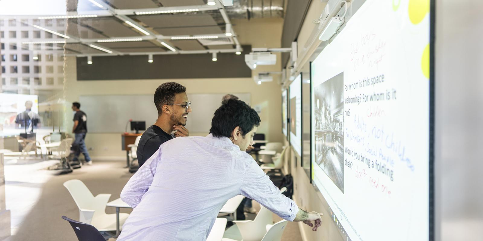 students on smart board working together