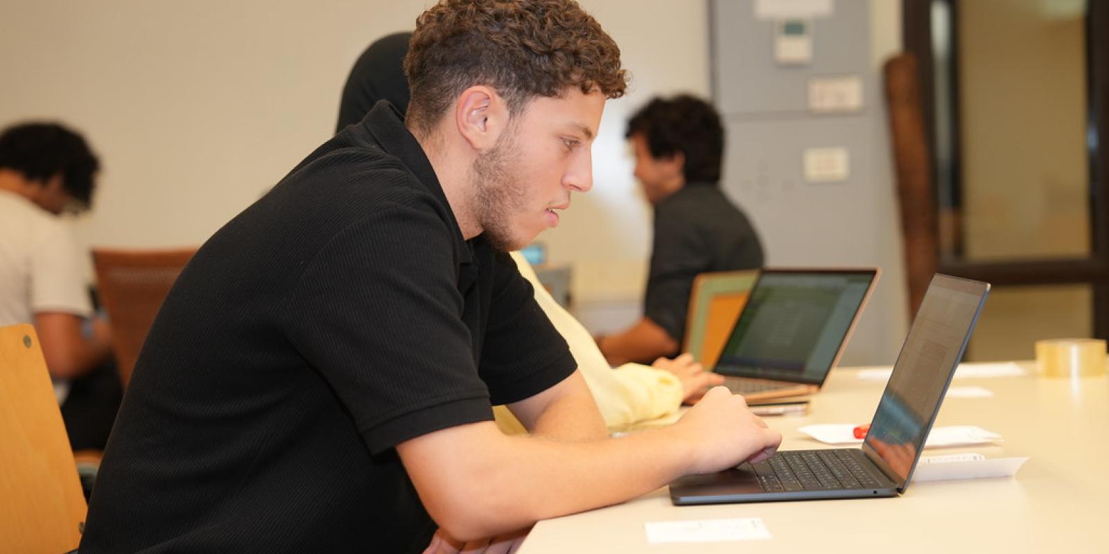 students in class working on laptop
