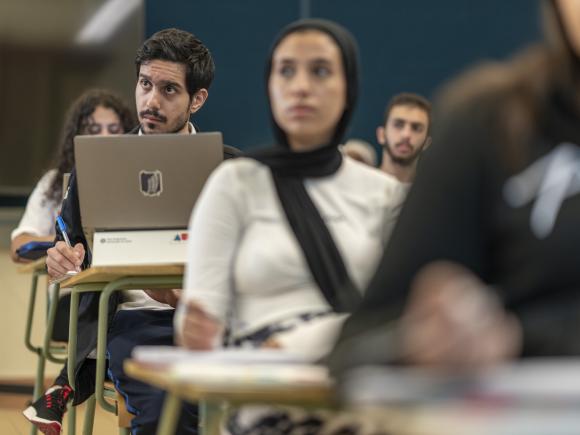 student focusing in class and taking notes on laptop