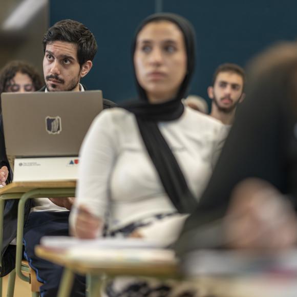 student focusing in class and taking notes on laptop