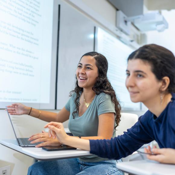 students smiling working on class assignment